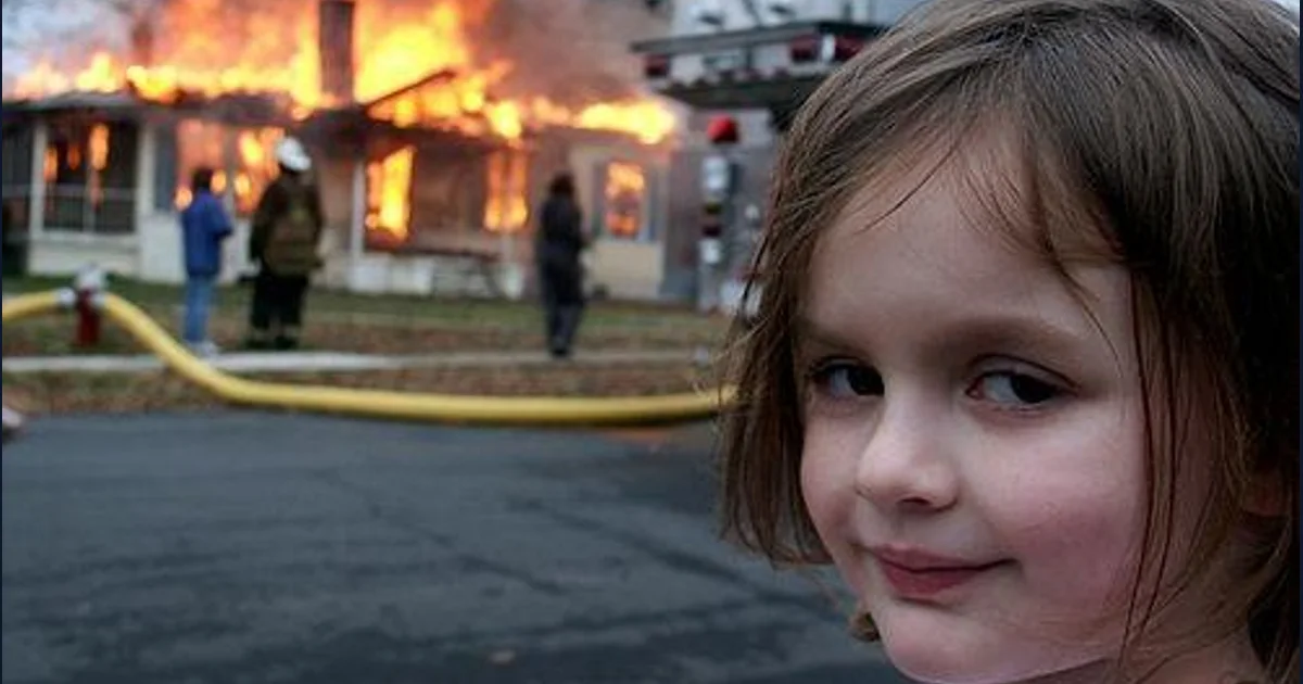 Zoe Roth smiling in front of a controlled training fire in the Disaster Girl photograph (reference preview)